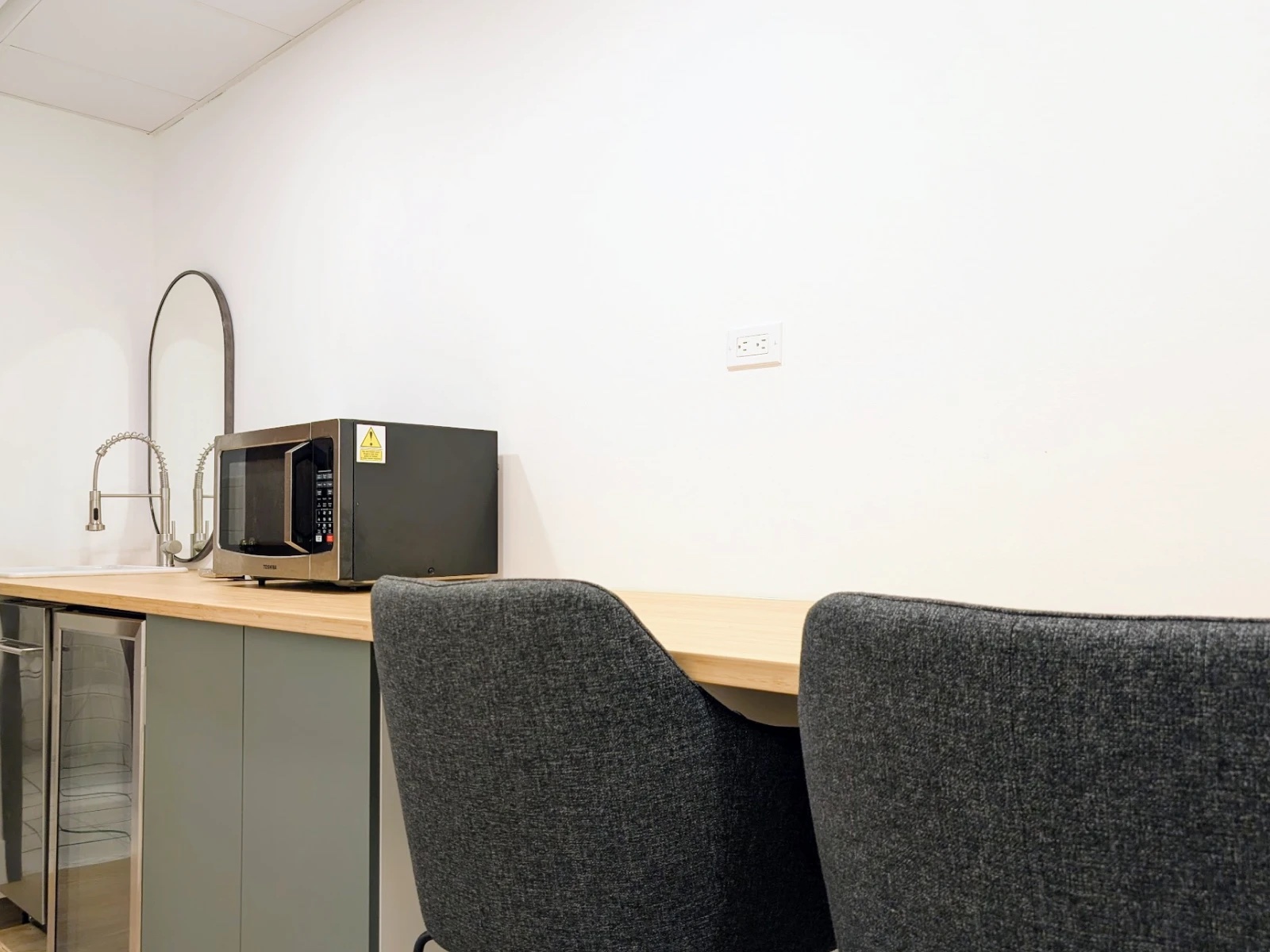 Kitchenette at HudsonDesk with a butcher-block counter, sink, microwave, and beverage fridge